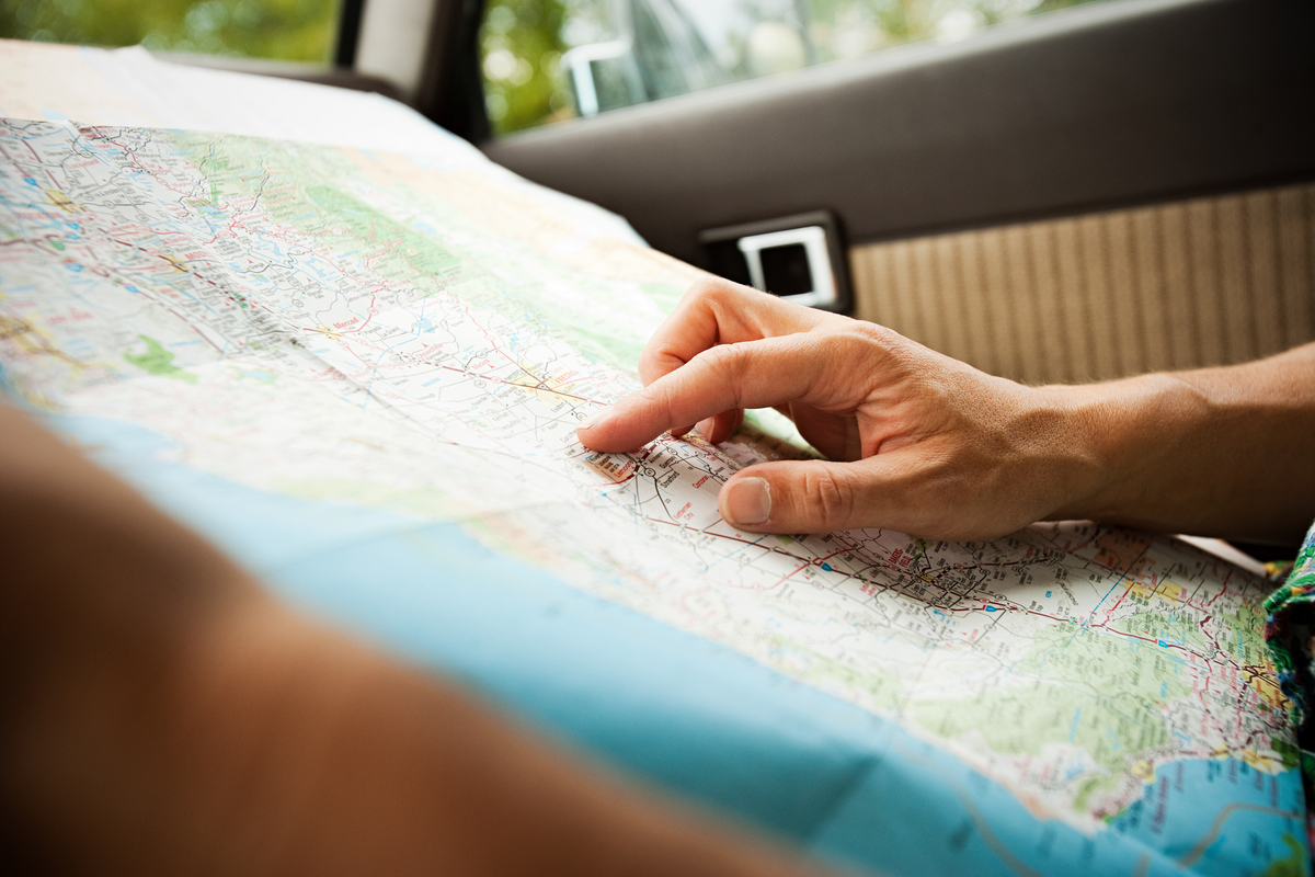 Person pointing on a map in a car