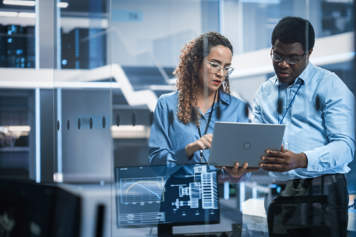 Two data scientists reviewing their work ona computer screen