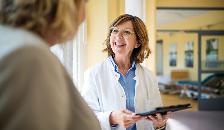 Provider taling to a patient. She is holding a tablet