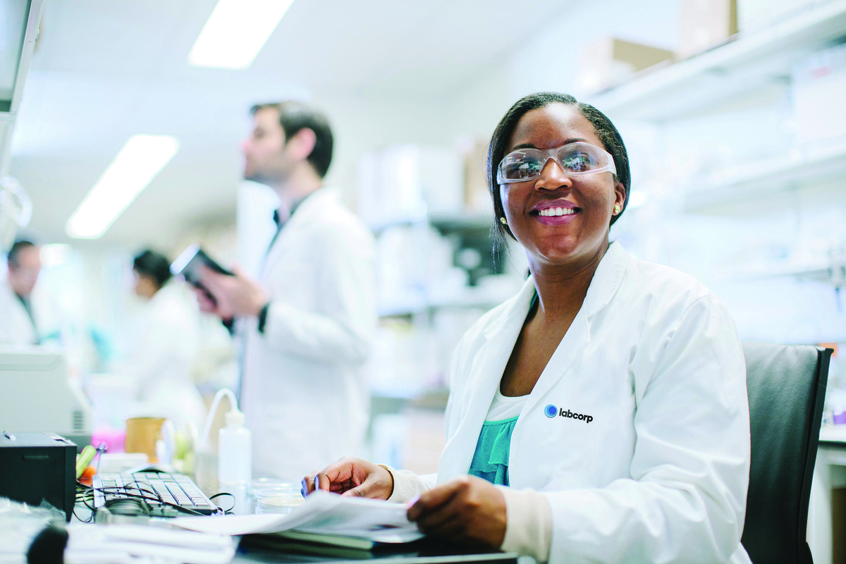 Woman sitting in a lab with a smile on her face.