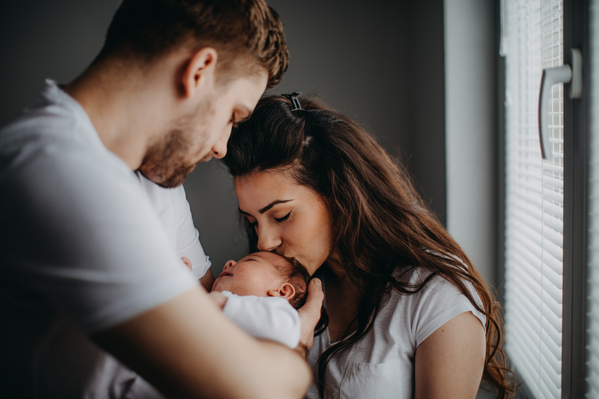 Smiling young parents with their baby girl at home