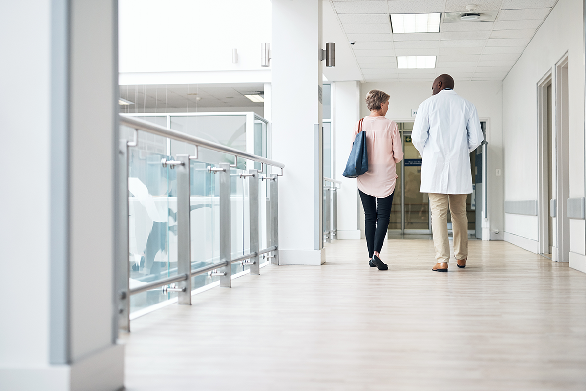 Provider walking with a patient in a hallway