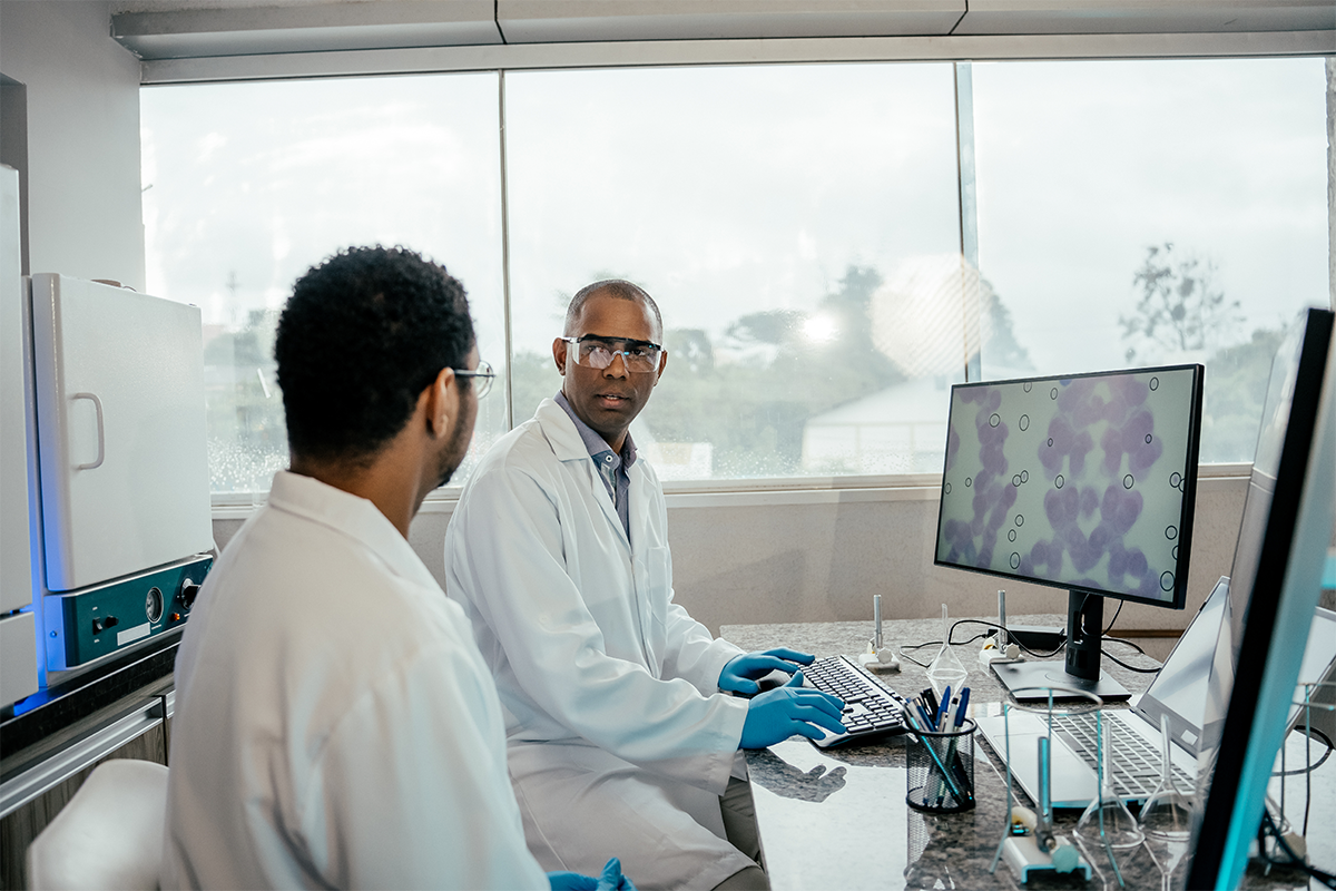 Two scientists reviewing pathology samples at a desk