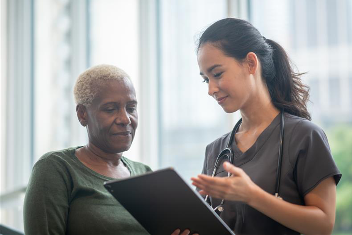 Provider talking to a patient about her results. The provider is holding a tablet